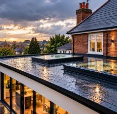 Seamless flat roof installation on modern kitchen extension with glass roof lanterns and skylights
